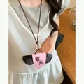 Detailed view of a pink leather sunglass holder necklace with sun embroidery on a model. - Necklace-Coffee-Pink