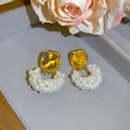 Detailansicht eleganter französischer Vintage-Perlenohrringe mit Goldfinish auf einem Tablett - Silber-Ohrstecker-Stil / Gold Weiß