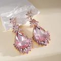 Close-up van elegante roze druppelvormige kristallen oorbellen met bloemaccenten - Zilveren Stift Roze Bloem Waterdruppel (1#) / Set van 1 paar / Goud