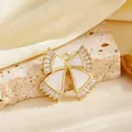 Close-up van elegante vergulde strikhanger met witte inleg en fonkelende kristallen. - Witte Strik Strass Hanger (Alleen Hanger)