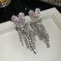 Close-up van roze hartvormige kwastjesoorbellen met fonkelende strass-steentjes. - Zilveren Stift Roze Volledig Diamanten Hart Kwastje (20#) / Set van 1 paar / Zilver