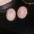 Macro-detail van luxe roze ovale oorbellen met een sprankelende zirkoon-halo - Ovale Roze Zirconia (32#) / Set van 1 paar / Goud