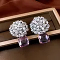 Macro view of beaded zircon earrings with square purple pendant on a jewelry box - Gold-Gray-Purple