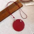 Detail of a minimalist red leather circular pendant necklace with stitching - Round Pendant Style / Red