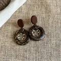 Detailansicht von böhmischen Ethno-Ohrringen im Vintage-Stil aus Holz und Muschelmaterial. - Gewebter Traumfänger Stil