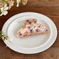 Detailed macro view of a stylish cream acrylic hair claw clip with colorful floral prints - Beige