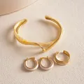 Detailaufnahme eines goldenen Retro-Schmucksets mit cremefarbenem Acetat-Muster - Dreiteiliges Set / Gold-Beige