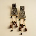 Gros plan de boucles d'oreilles vintage avec pompons en métal et perles marron. - Clous Gland Tige en Argent / Or Antique