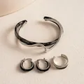 Nahaufnahme eines dreiteiligen Schmucksets mit unregelmäßigem Acetat und Silbermetall - Dreiteiliges Set / Silber-Schwarz