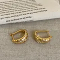 Nahaufnahme von 18k vergoldeten Creolen mit strukturierter Oberfläche und Zirkonia - Rund gewebte Textur Ohrenschnalle / Gold
