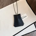 Detailopname van een zwarte lederen geometrische hanger aan een lange halslijn - Ketting / Zwart