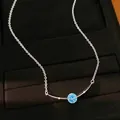 Detail van een zilveren ketting met een ronde blauwe zirkoon en gebogen hanger luxe - Gebogen Boogstijl / Blauw