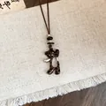 Vue détaillée d'un pendentif ours à motif léopard marron sur un collier en cuir - Ours / Marron