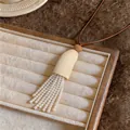 Elegante ketting met meerstrengs parelkwastje en bruin lederen koord hanger detail - Koffie Parel Kwastje Stijl / Lange Trui Ketting