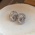 Dettaglio orecchini a lobo ovali argento con design a maglia intrecciata chic. - Argento