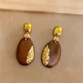 Detailansicht von ovalen Holzohrringen mit Goldfolie und kleinen weißen Perlen - Goldfolien Ovaler Stil (HE35634) / Silbernadel / Goldbraun