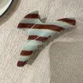 Close-up van een mintblauwe en bruin gestreepte acetaat haarklem op gestructureerde stof - Standaardtype / Blauwe en Koffie Haarklem