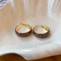 Boucles d'oreilles créoles émaillées marron à pois blancs dans une coupelle coquillage. - Brun doré