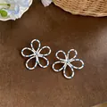 Boucles d'oreilles fleurs blanches à pois bleus sur fond bois rustique. - Blanc