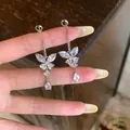 Detailopname van elegante zilveren vlinder oorbellen met fonkelende zirkonia's - Vlinder Kwastje Oorknopje / Zilver