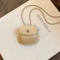 Gedetailleerde close-up van een beige vintage lederen zakje hanger aan een bruin koord - Ketting Lichtbruin