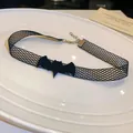 Détail d'un tour de cou gothique en résille noire avec un pendentif de chauve-souris - Style Chauve-souris