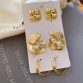 Set aus drei goldfarbenen Ohrringen mit geometrischen Texturen auf Displaykarte. - Vintage Plissiertes Ohrring-Set (HE35832) / 3er Set / Gold