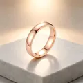 Gros plan d'une bague minimaliste en acier titane rose doré sur un socle en marbre - Taille 6 / 4mm Largeur / Or rose