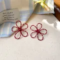 Detailed view of red hollowed-out flower earrings with white polka dots and silver needle - Hollow Flower (Silver Post) / Red