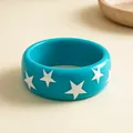 Detailopname van een blauwe harsarmband met witte sterren op een neutrale achtergrond - Blauw met witte sterren