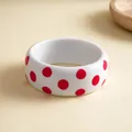 Detailopname van witte harsarmband met rode stippen voor een retro modieuze look - Wit met rode stippen