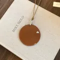 Collier porte-lunettes rond en cuir marron avec coutures blanches et cordon beige. - Marron