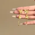 Détail de boucles d'oreilles papillon dorées vintage avec zircons brillants - Or