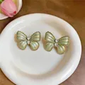 Detailopname van bosgroene vlinder oorbellen met gouden randen en stenen - Emaille Gradiënt Vlinder Oorknopjes (5#) / Goud-Groen
