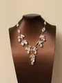 Detailweergave van onregelmatige barokparel kwastjesketting op bruine buste - Korte Stijl / Goud-Wit