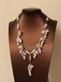 Gedetailleerd overzicht van een parelketting met onregelmatige vormen en goudkleur. - Lange Stijl / Goud-Wit