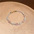 Eleganter goldener Armreif mit rosa quadratischen Zirkonia-Steinen auf Teller - Quadrat Armband / Gold-Rosa