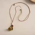Vue détaillée du collier bohème avec pendentif fleur en céramique et perles de bois - Coffee-Yellow