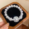 Nahaufnahme eines eleganten Perlenarmbands mit einem glitzernden Zirkon-Anhänger im Holzkästchen - Quadratisches Katzenauge Zirkonia Armband (HB6824)
