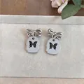 Elegantes pendientes de lazo plateados con delicados dijes de mariposa para mujer - Plateado