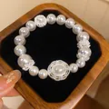 Nahaufnahme eines funkelnden Zirkon- und weißen Perlenarmbands mit silbernen Akzenten - Rundes Zirkonia Blumen Armband (HB6824)