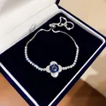 Detailaufnahme eines funkelnden Zirkonia-Armbands mit blauem Auge in einer Schmuckschatulle - 4# Armband