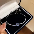 Detailansicht eines silbernen Evil Eye Armbands mit blauen Zirkonia in einer Geschenkbox - Stil 6
