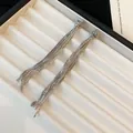 Détail de boucles d'oreilles minimalistes à pompons en argent avec chaîne nouée. - Boucles d'oreilles / Argent