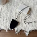 Minimalist black leather bell pendant necklace for glasses on textured background - Black