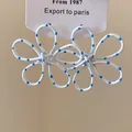Macro view of white flower drop earrings with blue polka dots and painted finish - 3D Wire Flower / White