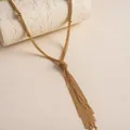 Nahaufnahme einer eleganten mehrlagigen Gold-Quastenkette mit feinen Metallketten - Gold