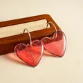 Vue détaillée de boucles d'oreilles cœur en résine rouge avec motif craquelé sur support en bois - Tige en Argent - Rose Rouge