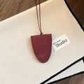 Close-up detail of burgundy suede eyeglass holder necklace with an elegant leather cord. - Burgundy