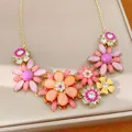 Macro view of a colorful vintage acrylic flower necklace with sparkling rhinestone accents - Pink-Purple
